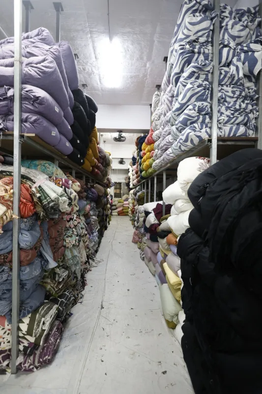 Printed fabric stock stored by design and colour at the Queenz Fabrica unit in Surat